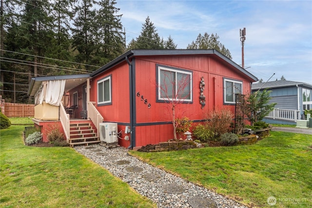 view of side of home with ac unit, a lawn, and fence