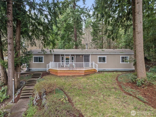 view of front of home with a front yard and a wooden deck