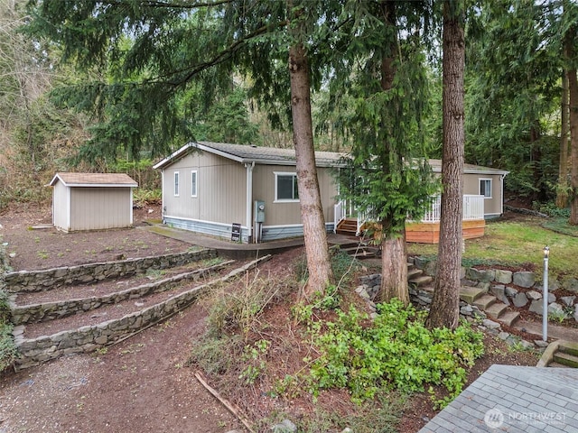 view of front of property with entry steps, an outbuilding, and a storage unit