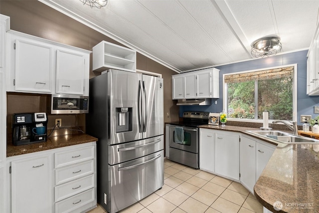 kitchen with lofted ceiling, a sink, ornamental molding, stainless steel appliances, and white cabinets