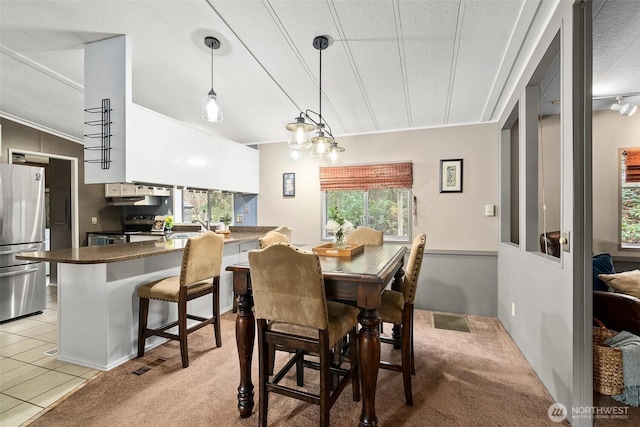 dining room with visible vents, light carpet, and light tile patterned flooring