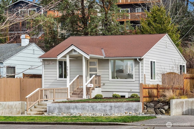 view of front of house featuring fence and a shingled roof