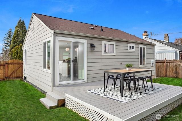 deck with a gate, outdoor dining area, a lawn, and fence