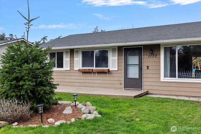 exterior space with a front lawn and roof with shingles