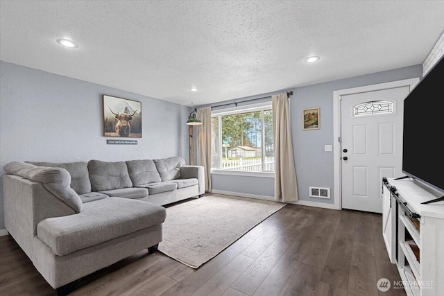 living area featuring baseboards, visible vents, recessed lighting, dark wood-style flooring, and a textured ceiling