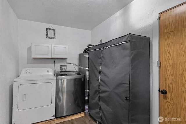 laundry area featuring independent washer and dryer, a textured ceiling, wood finished floors, water heater, and cabinet space