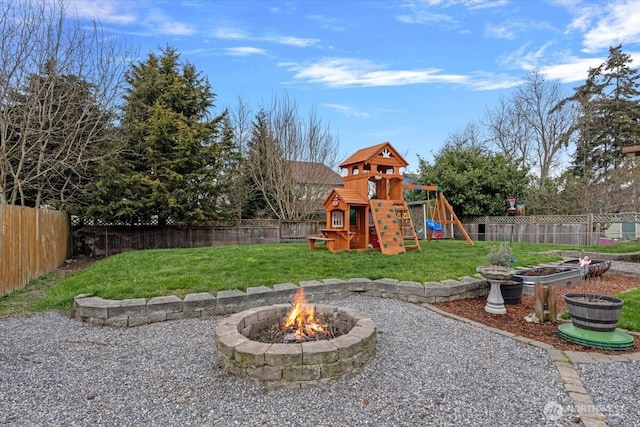 view of yard featuring a fire pit, a fenced backyard, and a playground