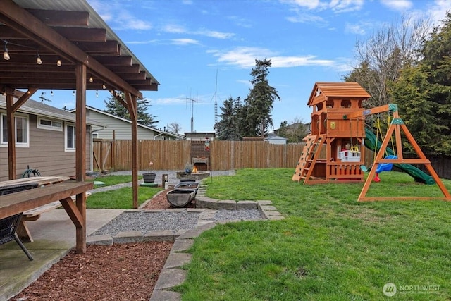 view of yard featuring a patio area, a playground, and a fenced backyard