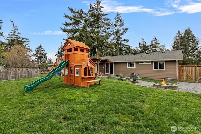 view of jungle gym with a lawn, a fenced backyard, and an outdoor fire pit