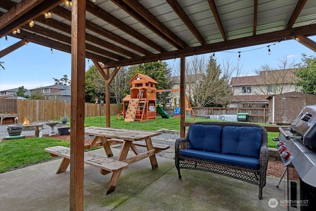 view of patio / terrace featuring an outdoor living space, a playground, area for grilling, and a fenced backyard