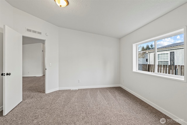 spare room featuring visible vents, a textured ceiling, baseboards, and carpet floors