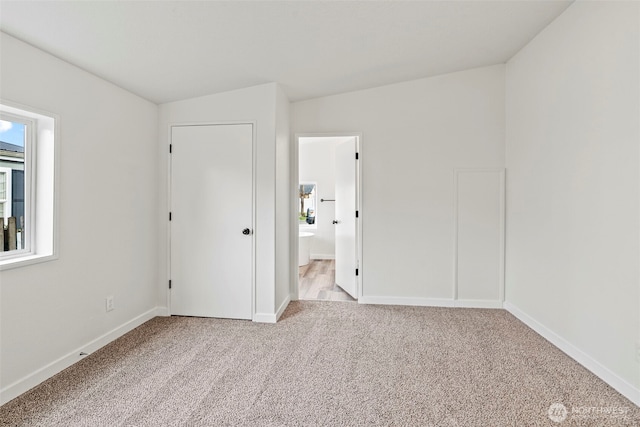 unfurnished bedroom with carpet, baseboards, and connected bathroom