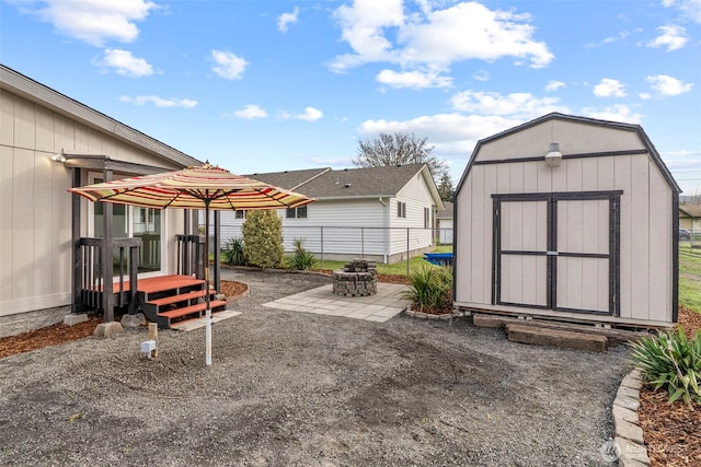 view of patio with a storage unit, an outbuilding, and fence