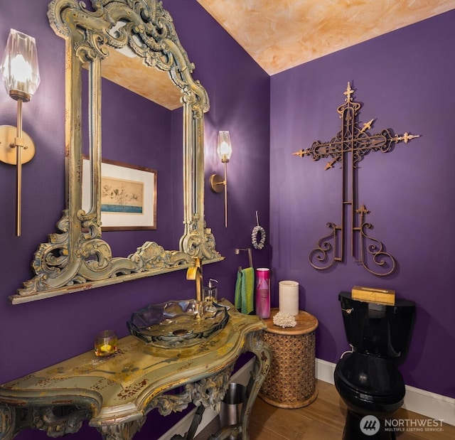 bathroom with baseboards and wood finished floors