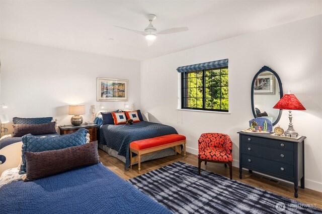 bedroom with ceiling fan, baseboards, and wood finished floors