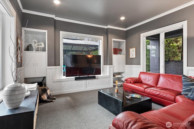 carpeted living area with recessed lighting, a decorative wall, wainscoting, and crown molding