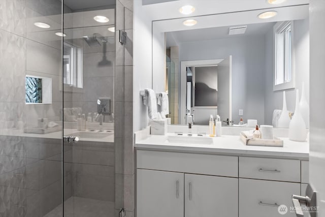 full bath featuring vanity, visible vents, and a stall shower