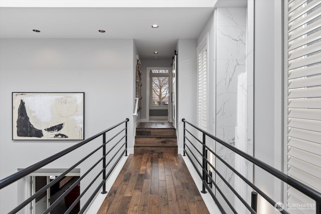 hallway featuring dark wood finished floors, an upstairs landing, and recessed lighting