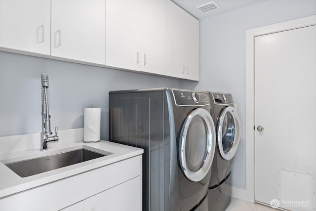 laundry area with visible vents, marble finish floor, independent washer and dryer, a sink, and cabinet space