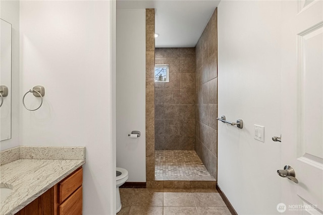 bathroom with vanity, baseboards, walk in shower, tile patterned floors, and toilet