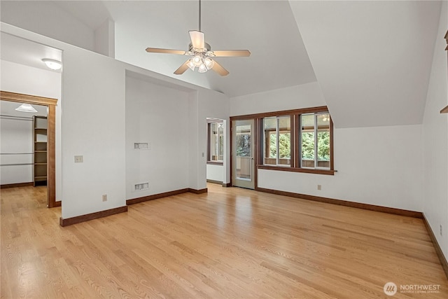 interior space featuring vaulted ceiling, light wood-style flooring, and baseboards