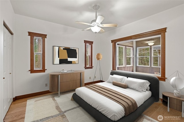 bedroom with light wood-style floors, baseboards, and ceiling fan