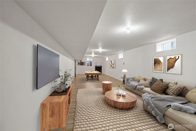 living room with visible vents, a textured ceiling, and wood finished floors