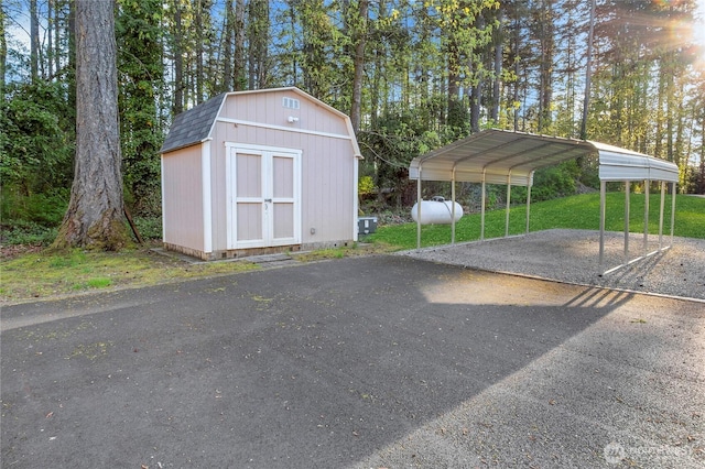 15809 Spanaway Loop Rd S, Spanaway, WA 98387 - view of parking / parking lot featuring a detached carport, aphalt driveway, and a shed