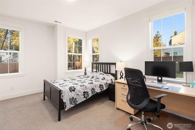 bedroom with visible vents, light carpet, and baseboards