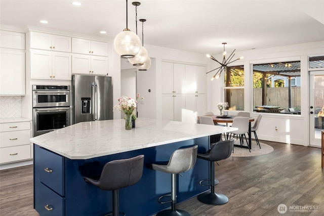 kitchen featuring a kitchen island, a chandelier, dark wood finished floors, appliances with stainless steel finishes, and white cabinetry