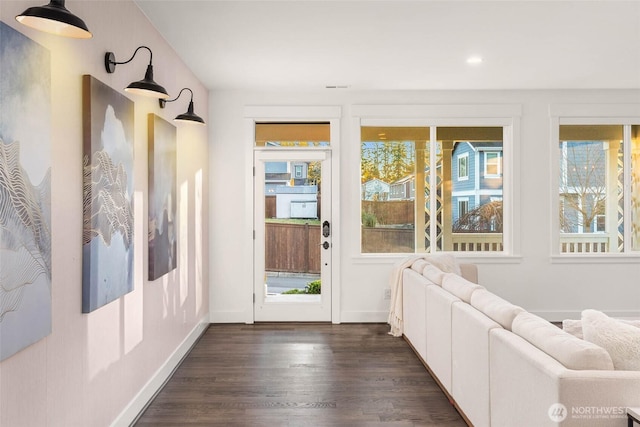 doorway to outside featuring dark wood-type flooring and baseboards