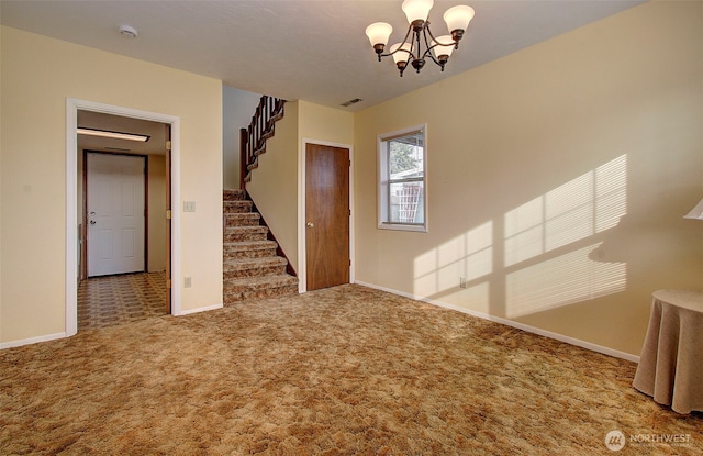 carpeted spare room with visible vents, baseboards, an inviting chandelier, and stairs