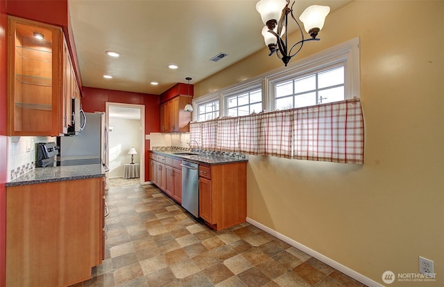 kitchen featuring baseboards, visible vents, a sink, appliances with stainless steel finishes, and tasteful backsplash