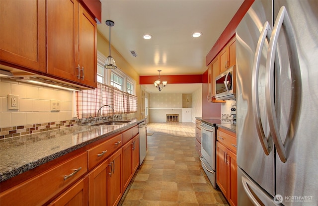 kitchen with a sink, brown cabinets, backsplash, and appliances with stainless steel finishes