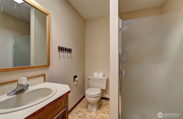 full bath with vanity, a shower stall, toilet, and baseboards