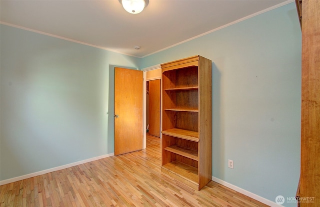 unfurnished bedroom featuring baseboards, light wood finished floors, and ornamental molding