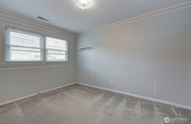 spare room with visible vents, wallpapered walls, carpet flooring, crown molding, and baseboards