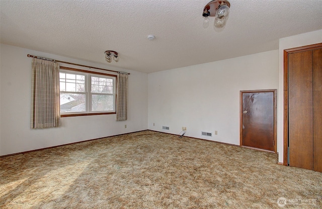 spare room with baseboards, visible vents, carpet floors, and a textured ceiling