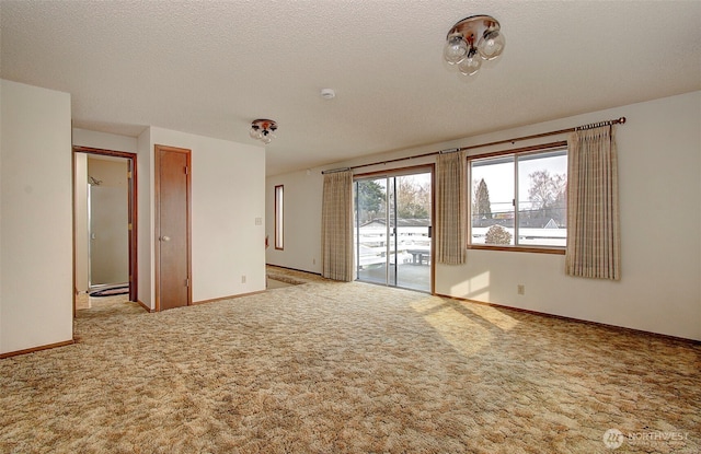 empty room featuring baseboards, carpet floors, and a textured ceiling