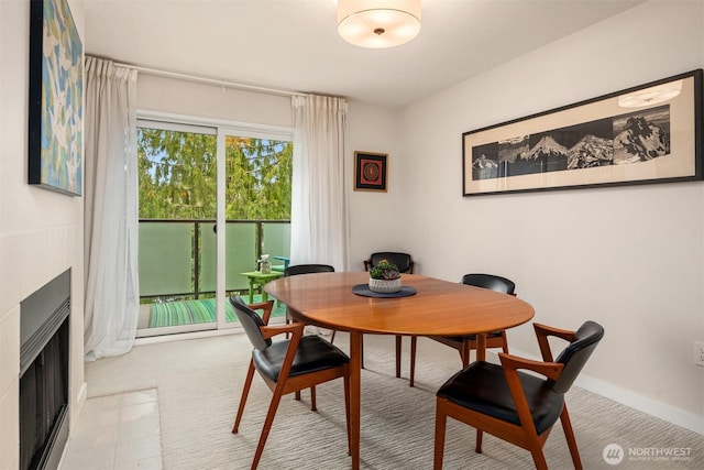 dining area featuring baseboards and a fireplace with flush hearth