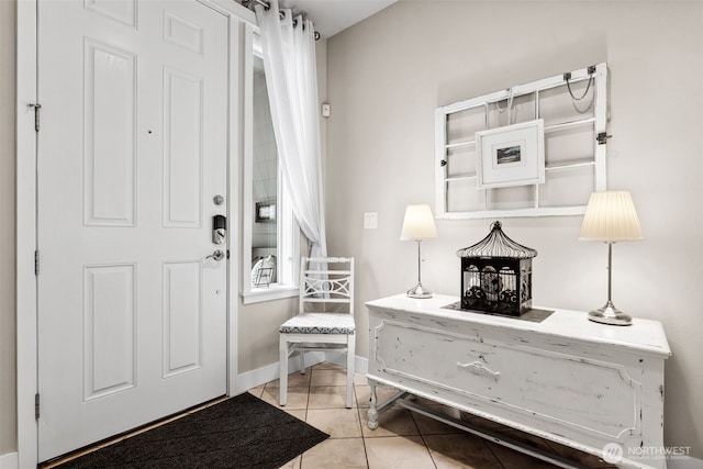 foyer featuring baseboards and light tile patterned flooring