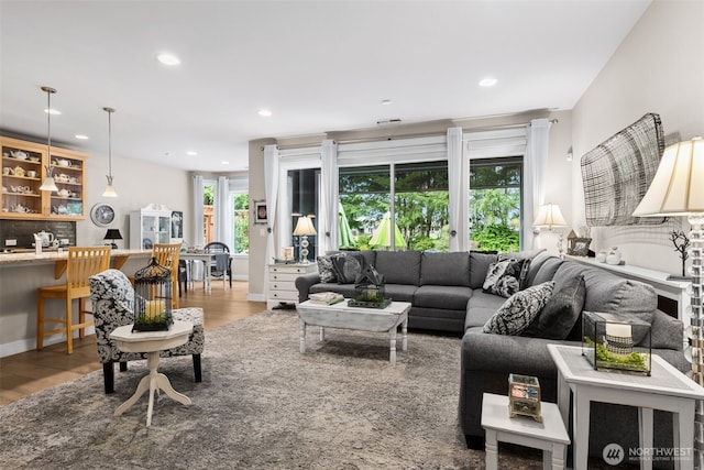 living area with recessed lighting, baseboards, and wood finished floors