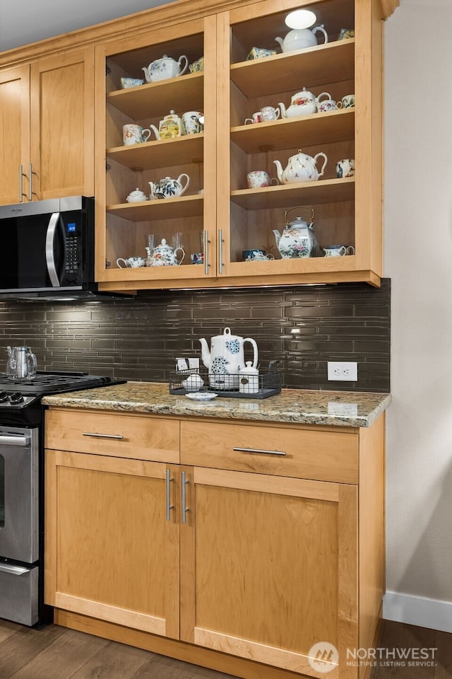 kitchen with light stone countertops, baseboards, open shelves, appliances with stainless steel finishes, and tasteful backsplash