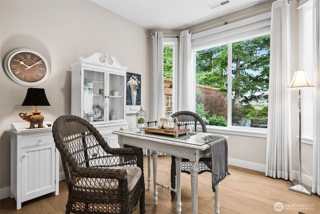 dining space featuring visible vents, baseboards, and light wood finished floors