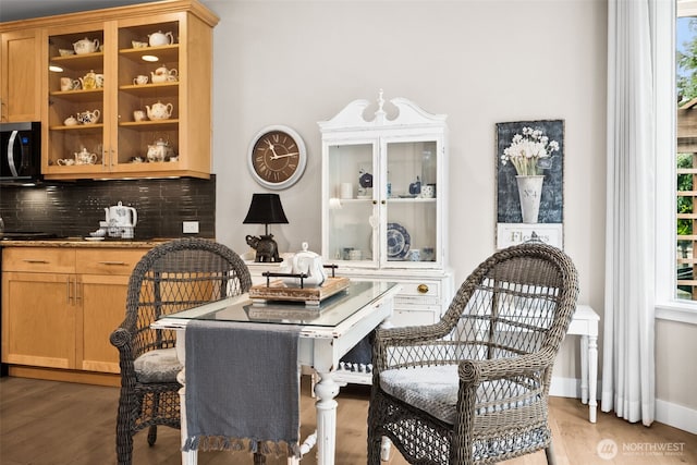 dining area with light wood finished floors and baseboards