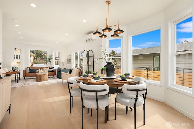 dining room with recessed lighting, light wood-style flooring, a wall mounted AC, and baseboards