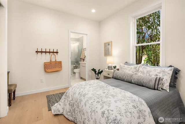 bedroom with recessed lighting, baseboards, ensuite bathroom, and light wood-style floors