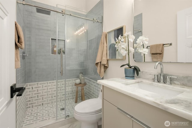 full bathroom featuring vanity, toilet, and a shower stall