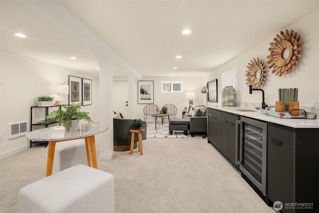 interior space with beverage cooler, visible vents, recessed lighting, a sink, and light colored carpet