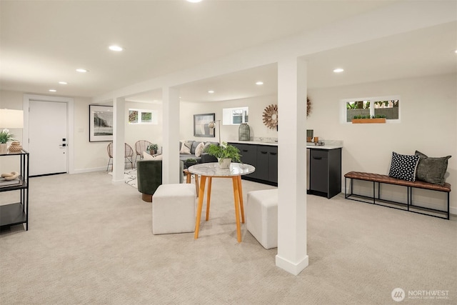 living room featuring recessed lighting, baseboards, light colored carpet, and a wealth of natural light